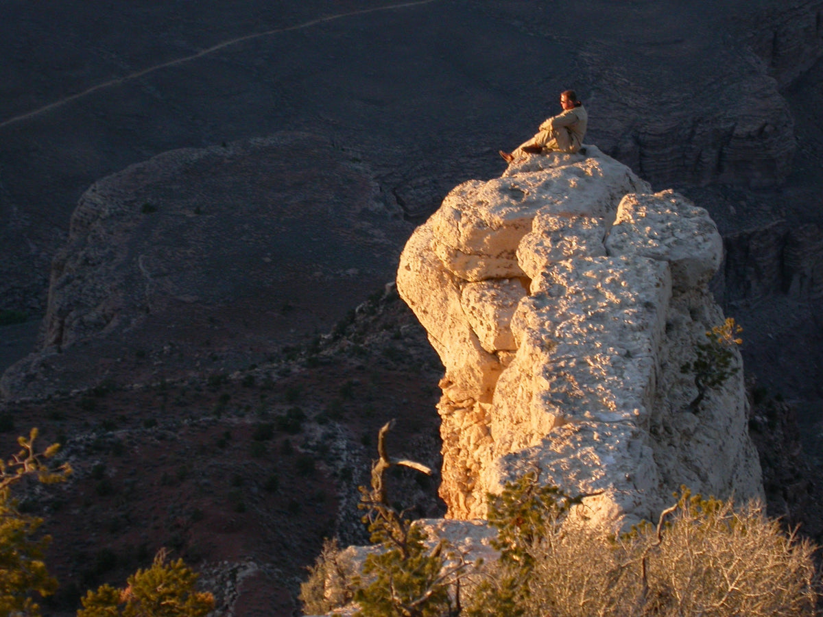Warm sunset light crossing the layered cliffs, ridges and deep valleys of Grand Canyon National Park.